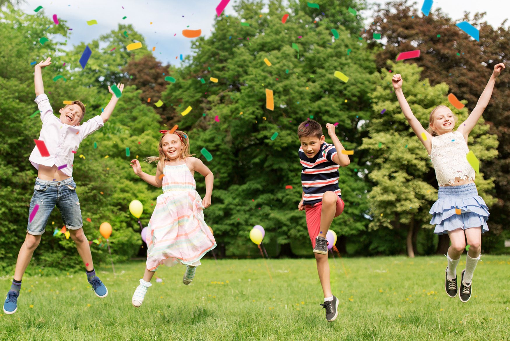 Kinder springen begeistert im Park mit Konfetti
