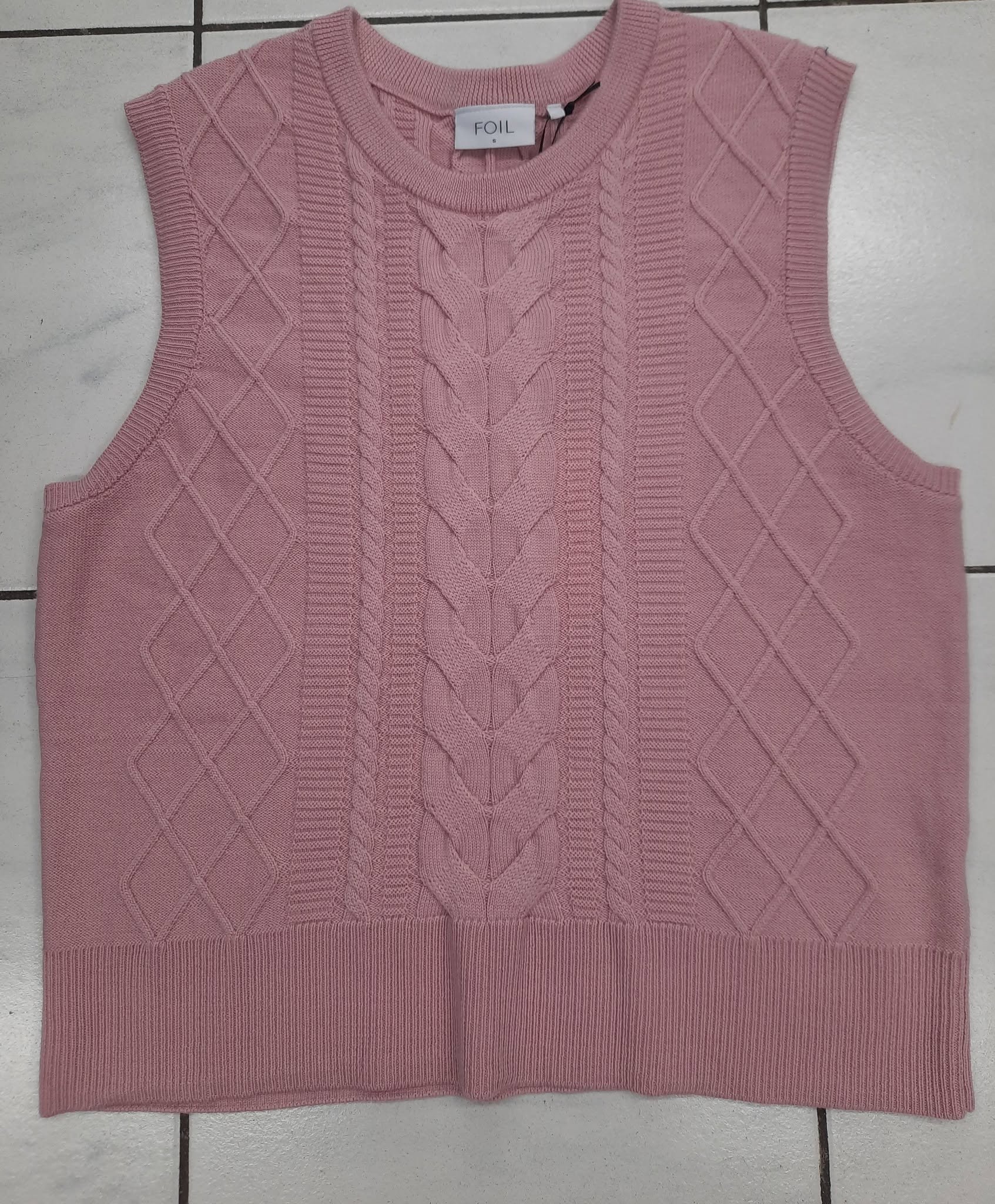 Bright berry-pink V-neck knit vest laid flat