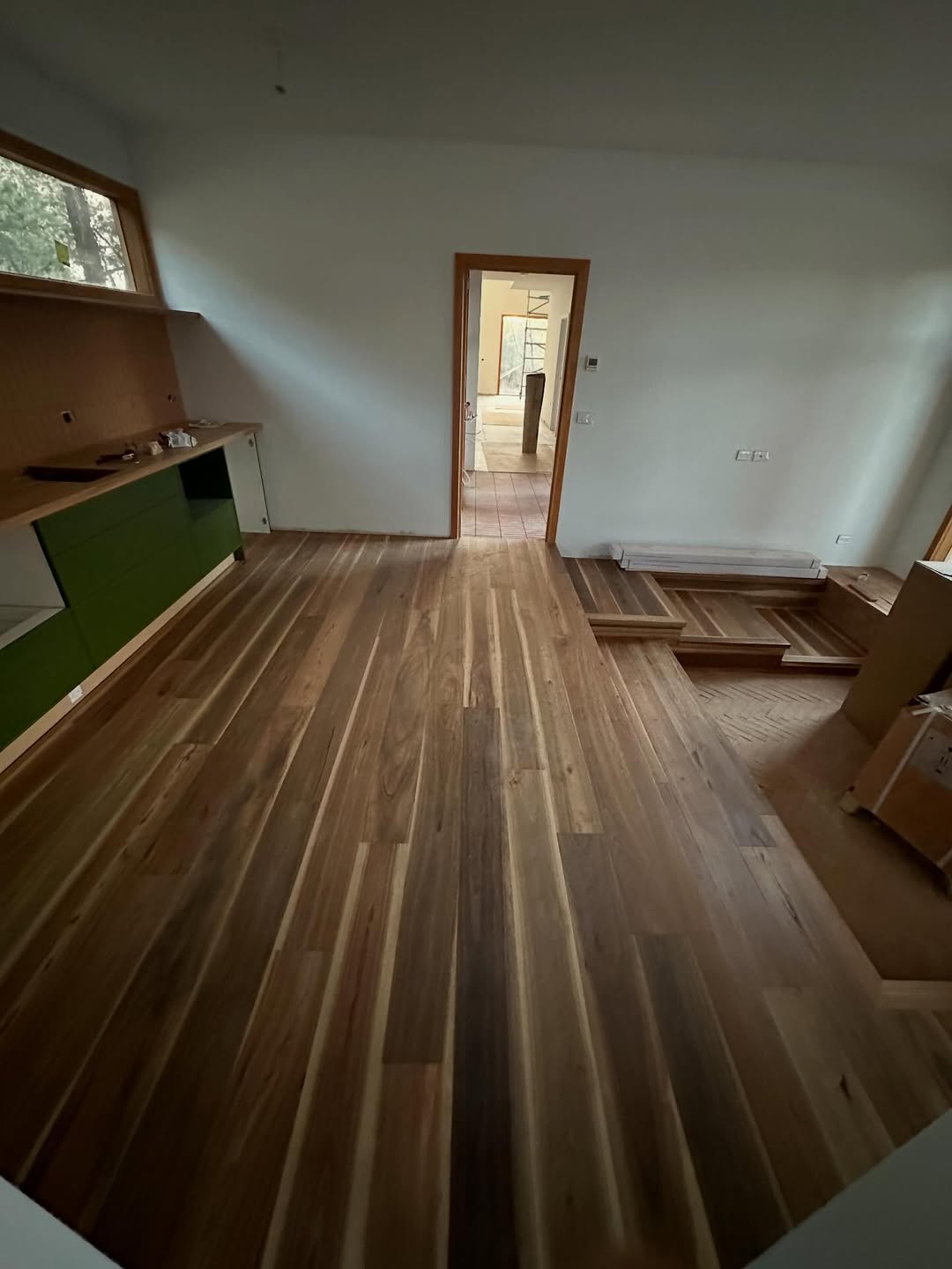 Dark Australian hardwood timber flooring during installation with warm timber door frames