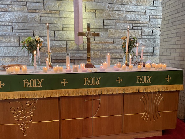The altar decorated with candles, flowers, and a cross for a special worship service