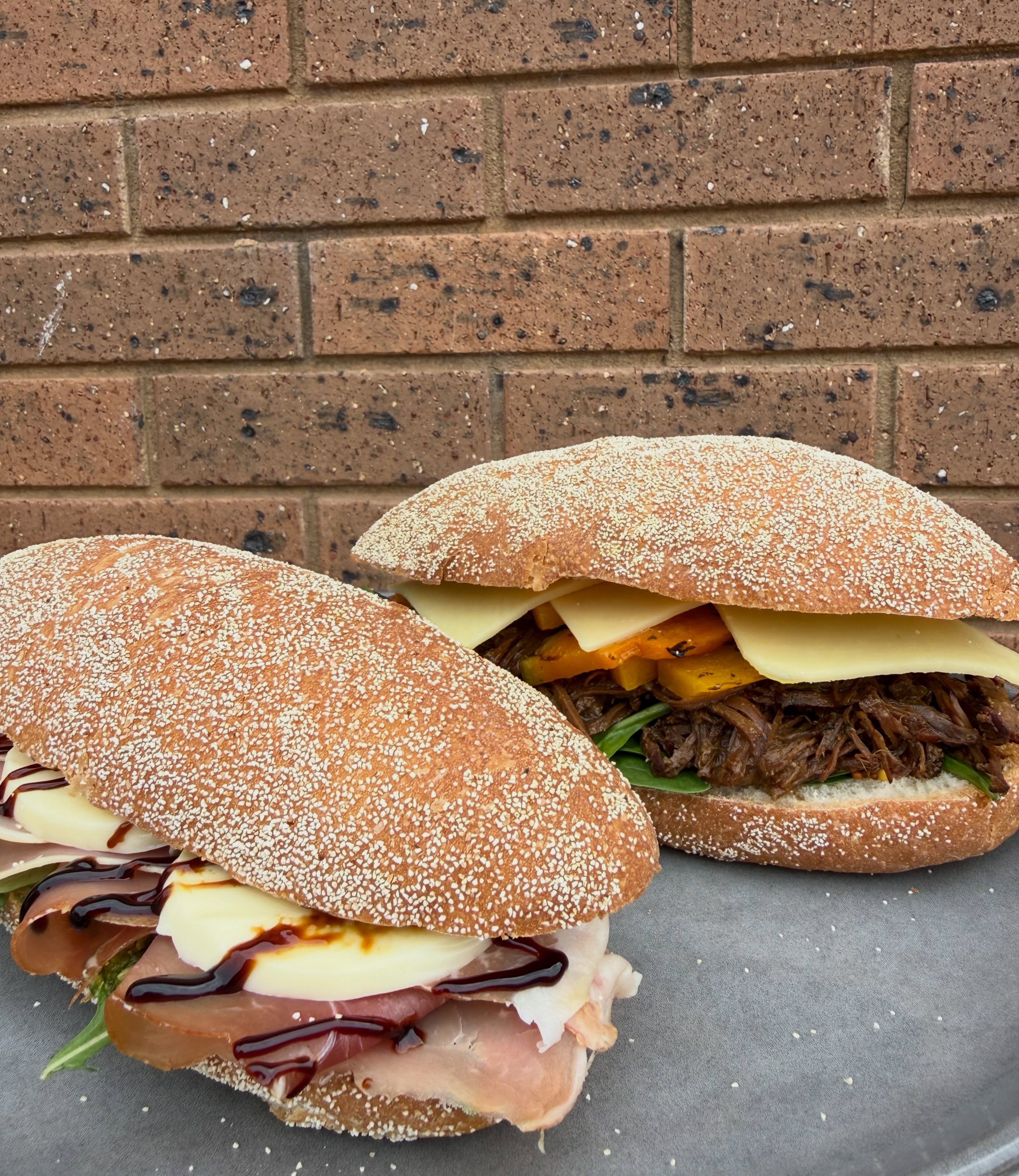 Toasted panini rolls with pulled meat and cheese at Milking It