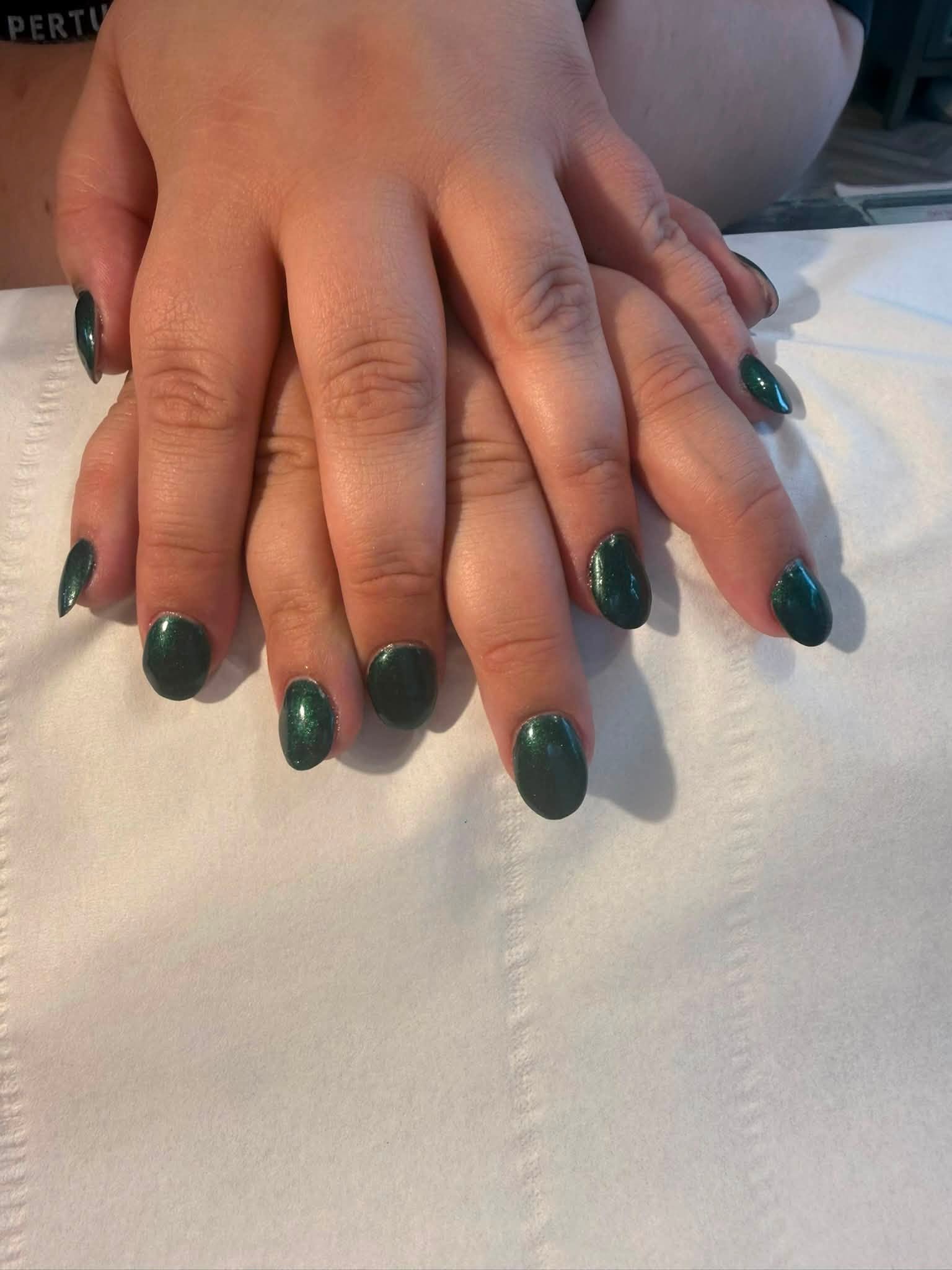 Deep emerald green gel nail polish on both hands