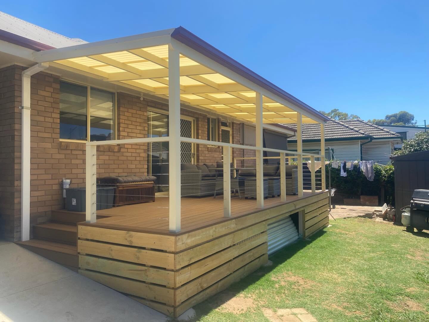 Finished raised deck with pergola and cable balustrade on a sunny day