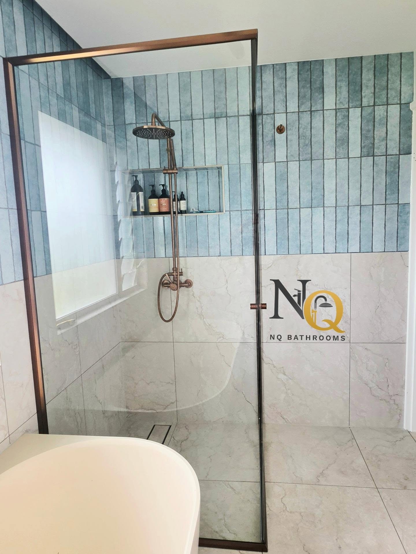 Shower recess with teal subway tiles and copper rainfall shower fittings