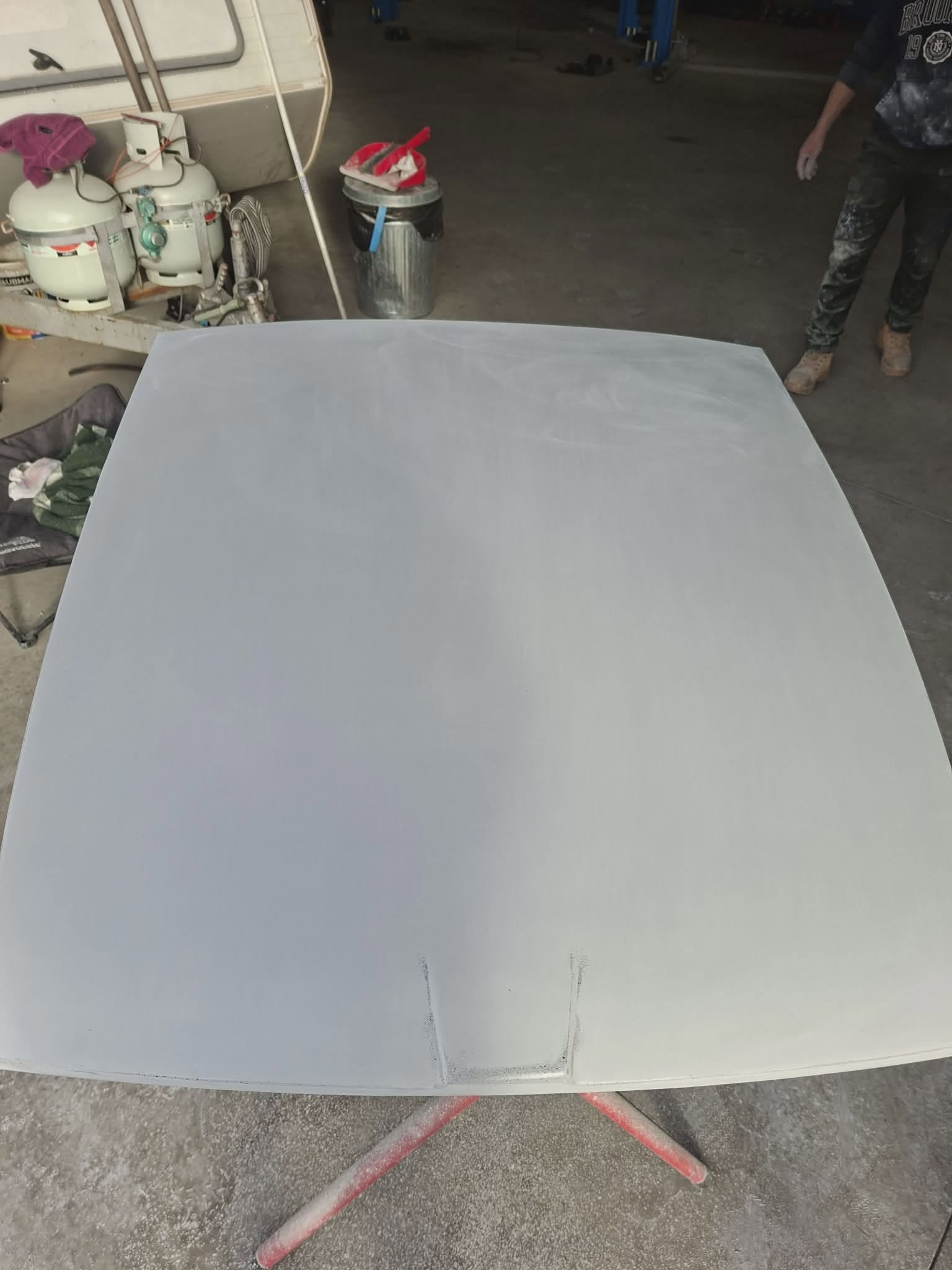 Classic car bonnet panel in grey primer on a paint stand — bodywork preparation at April Motors