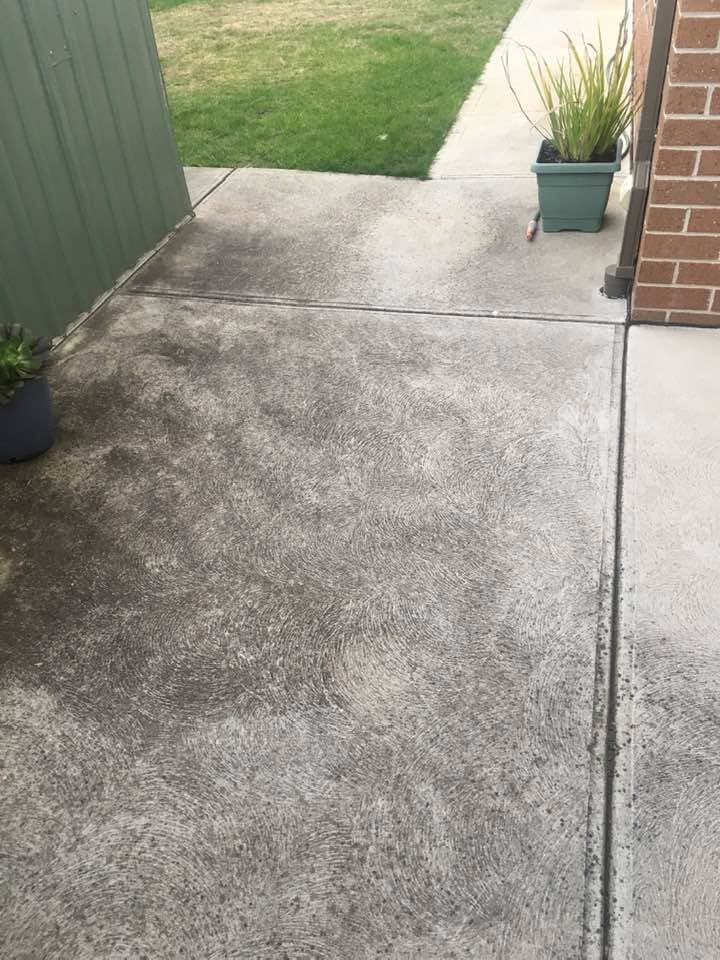 Clean concrete pathway next to a lawn after pressure washing