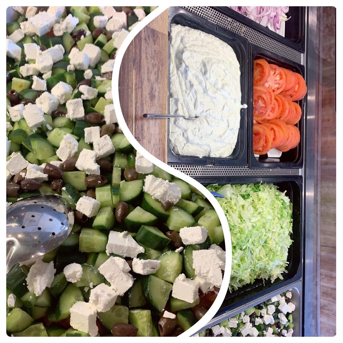 Fresh salad ingredients including feta, olives, cucumber, tomato and tzatziki prepared for souvlaki