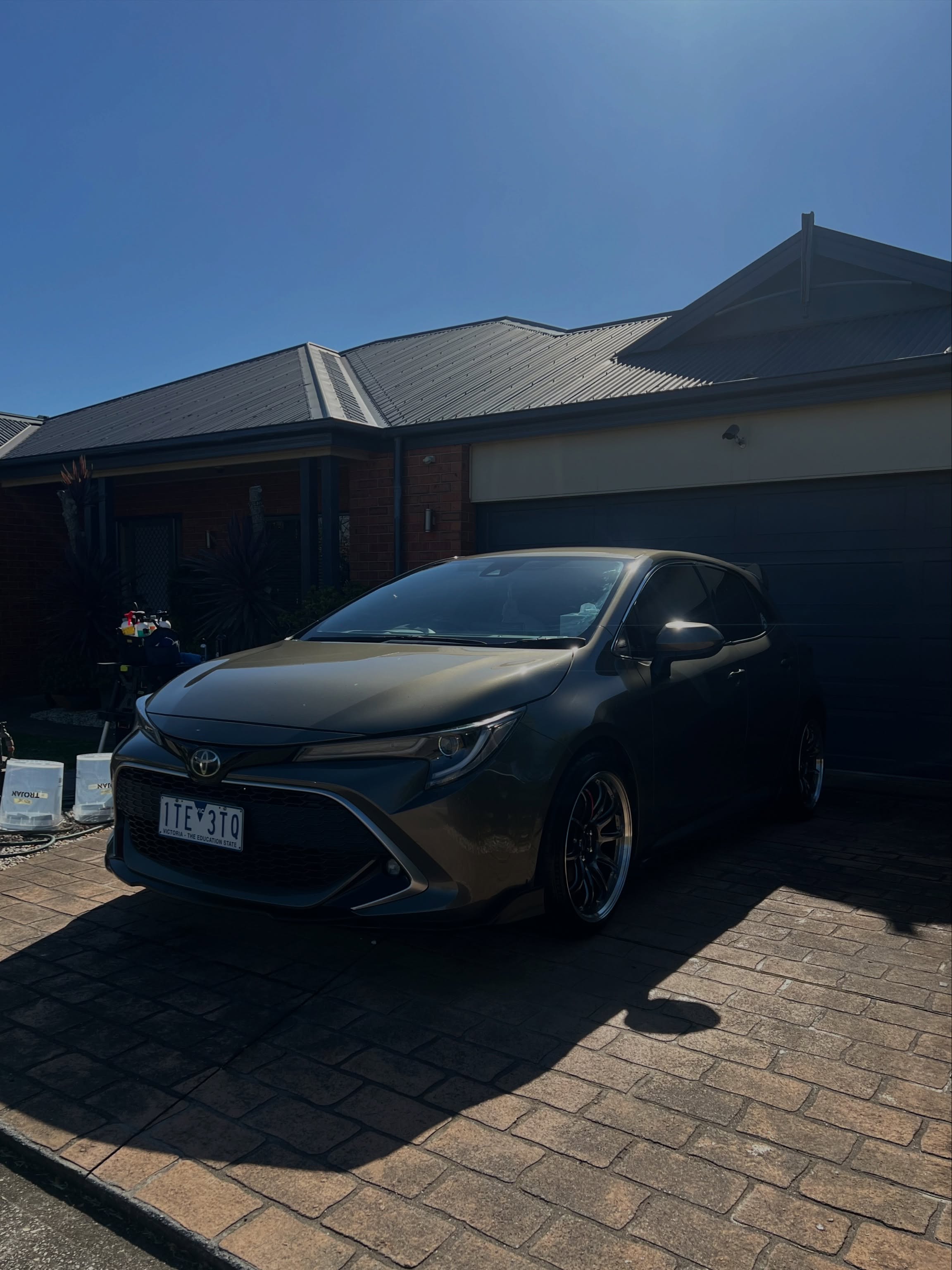 Freshly detailed Toyota Corolla parked in a driveway on a sunny day