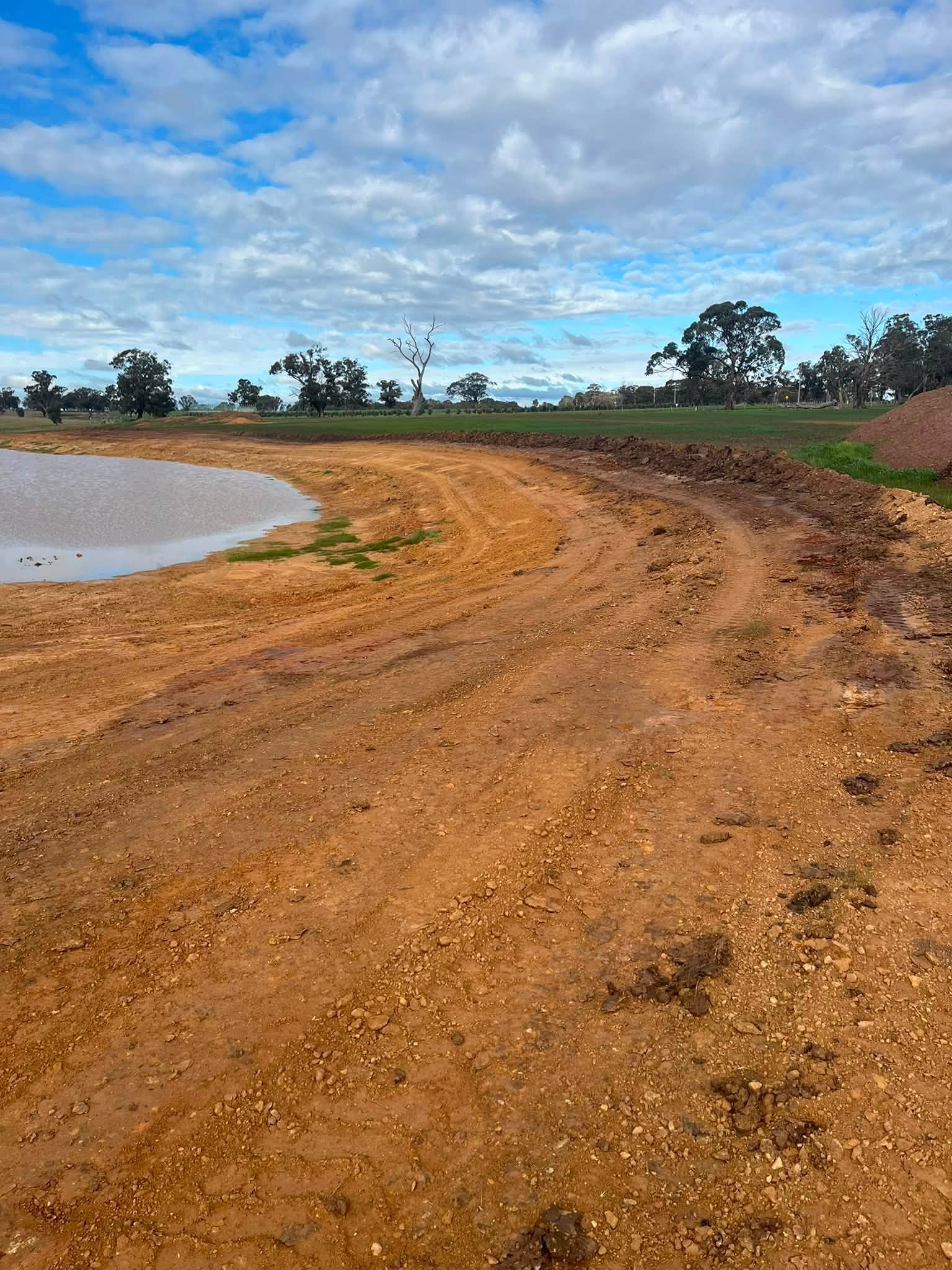 Freshly constructed earthworks dam wall and access track in Central Victoria