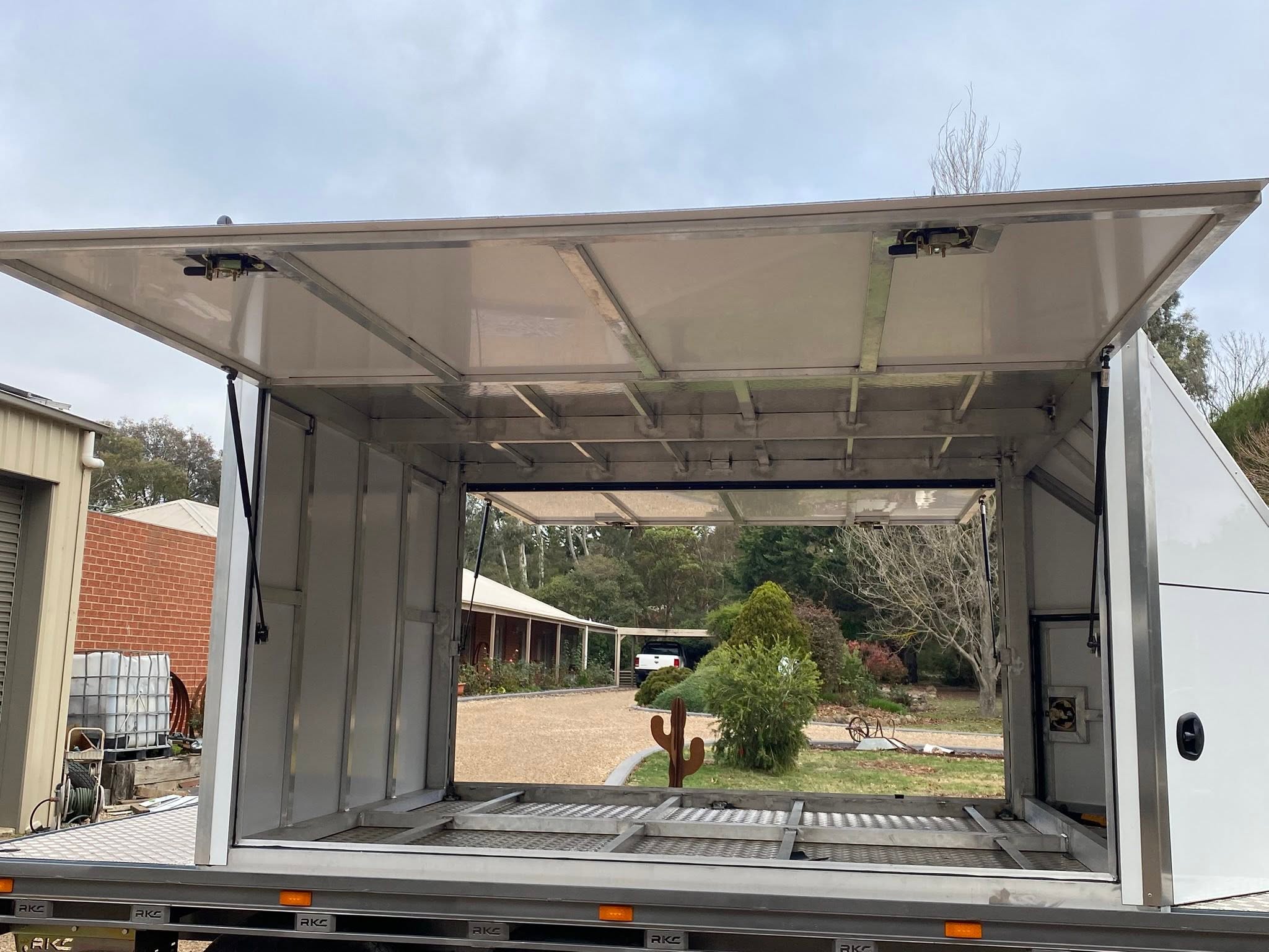 Open horse float with doors raised, showing rural backdrop