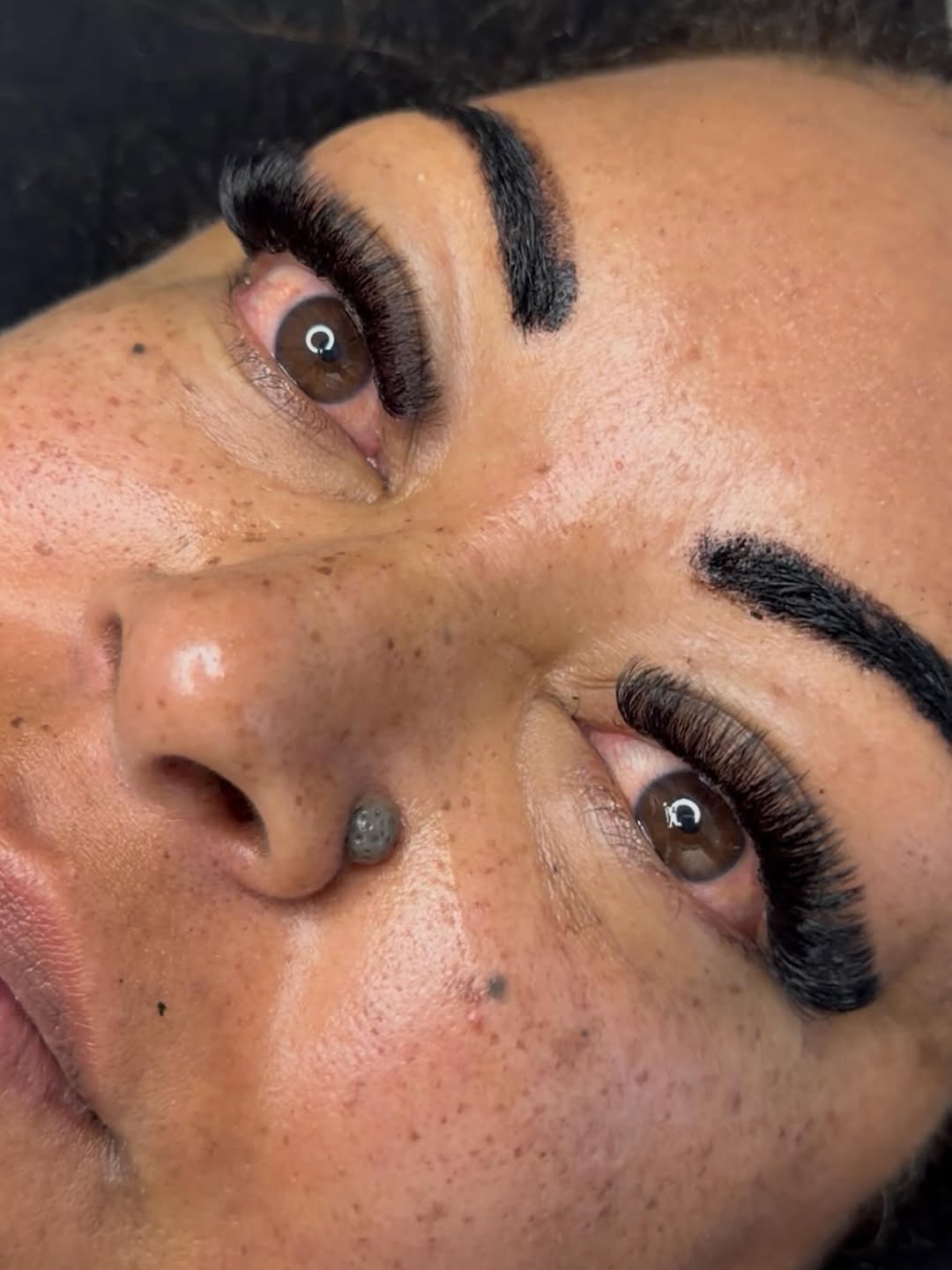 Close-up of dramatic, full eyelash extensions on brown eyes