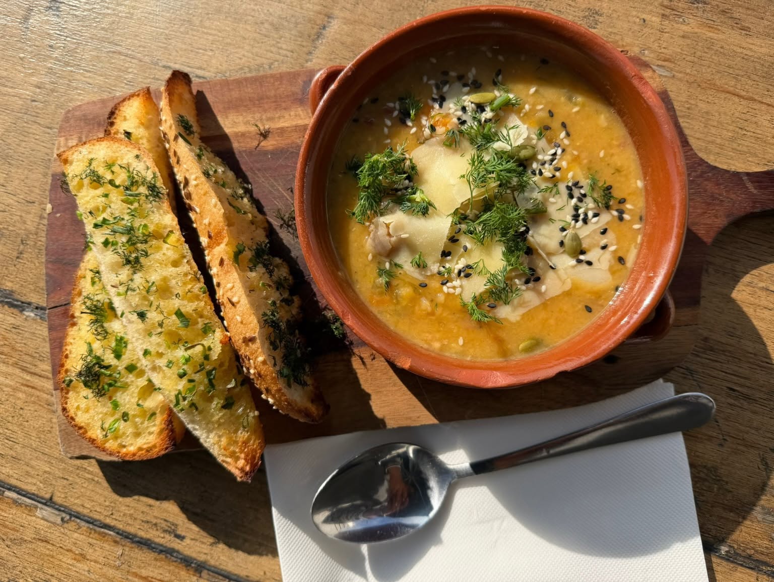 Bowl of vegetable soup with dill and toasted garlic bread