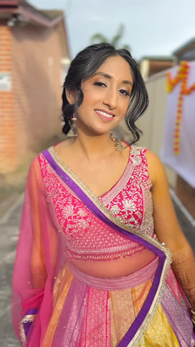 Fresh and joyful event makeup with soft curls on a client in a colourful lehenga