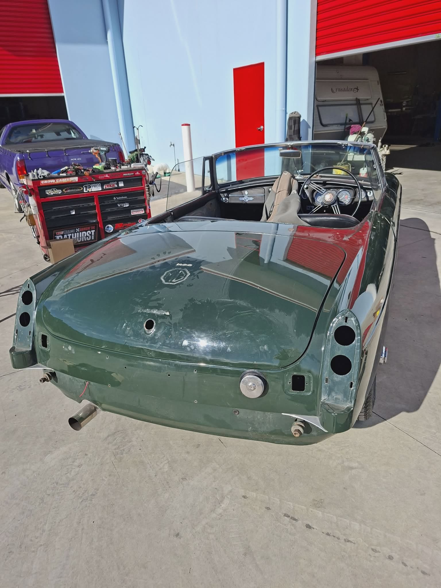 British Racing Green MGB rear view showing classic wire wheels and vintage trim detail