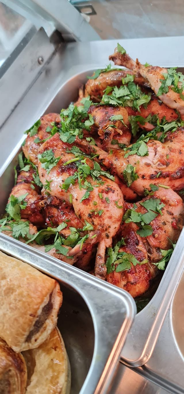 Freshly roasted chicken pieces with herbs in a deli tray at SPAR North Parramatta