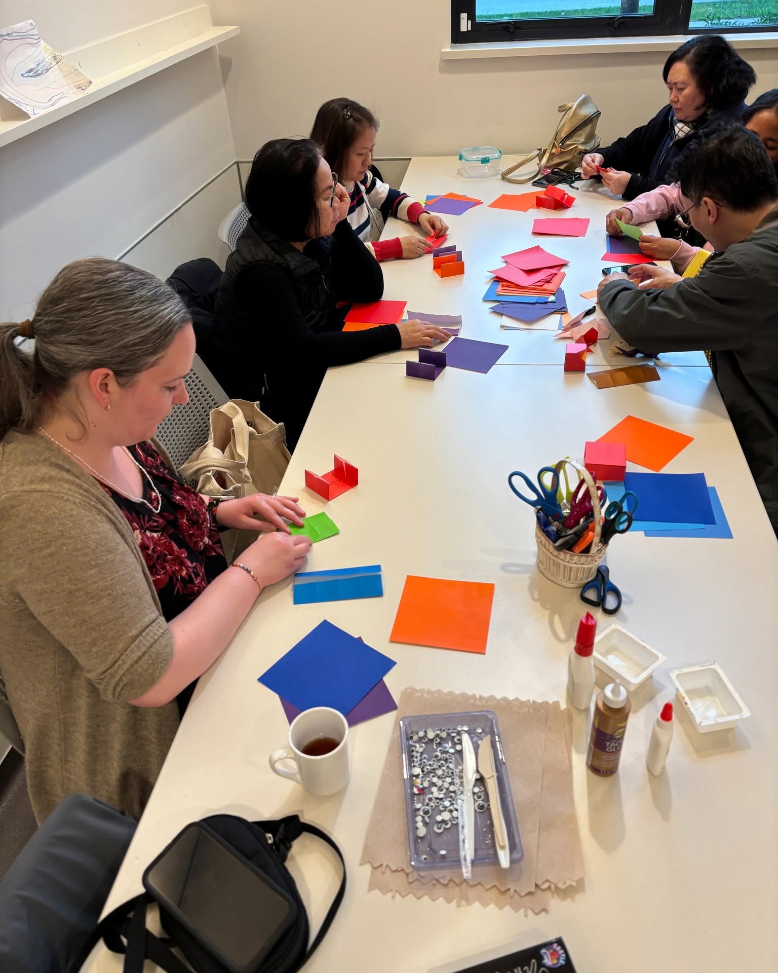 Community members doing arts and crafts with colourful paper at Collingwood Neighbourhood House