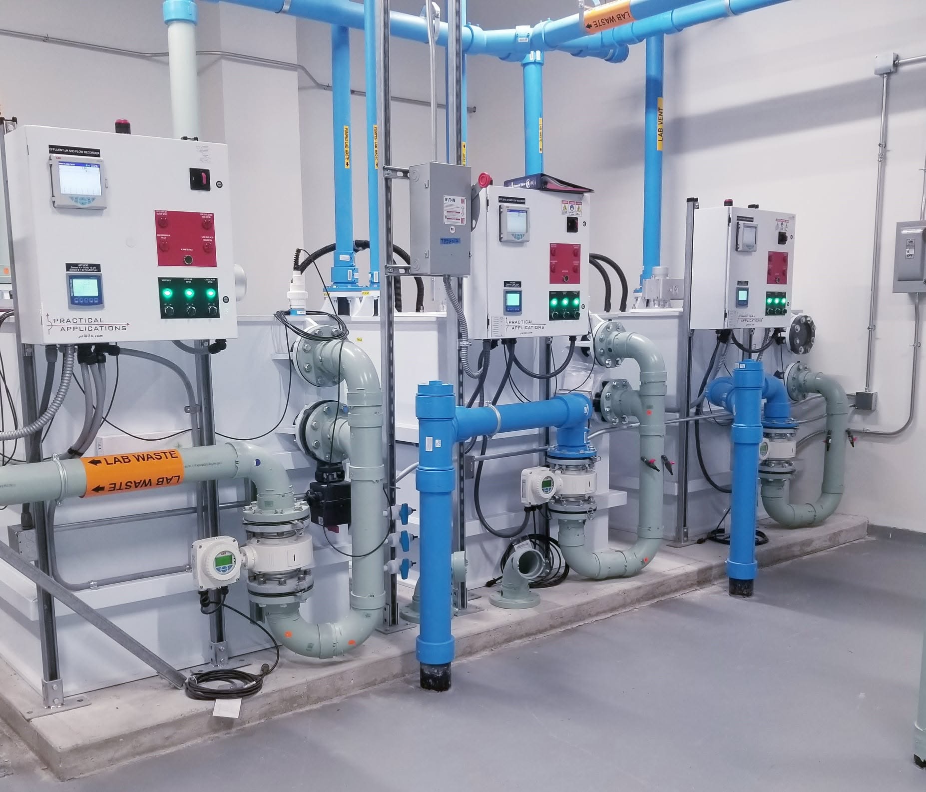 Industrial piping and control panel installation with blue pipes