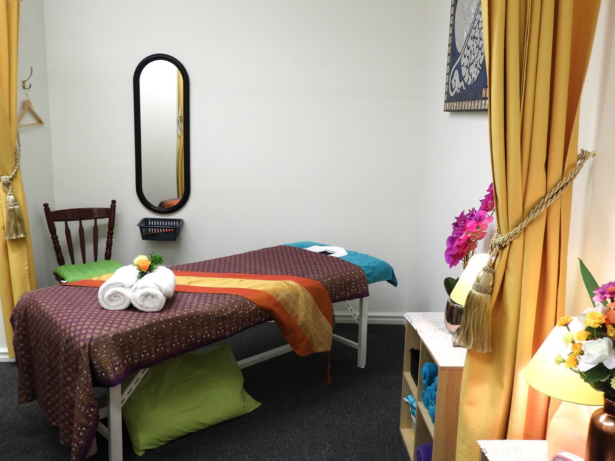 Treatment room with purple and gold Thai fabric massage table at Golden Orchid