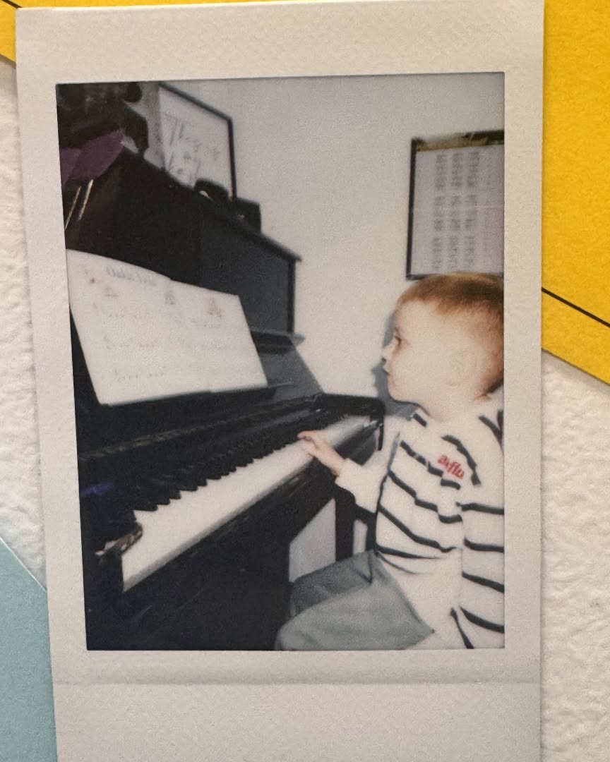 Young child playing an upright piano