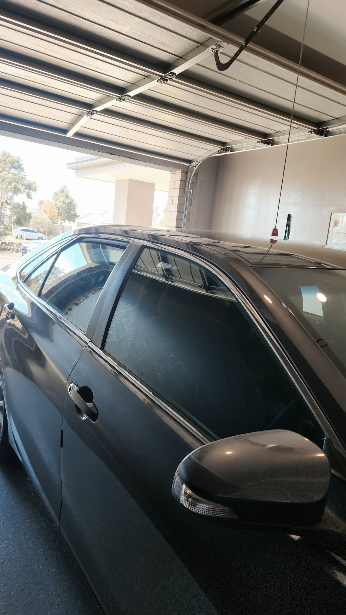 Dark sedan with tinted rear windows parked in a home garage