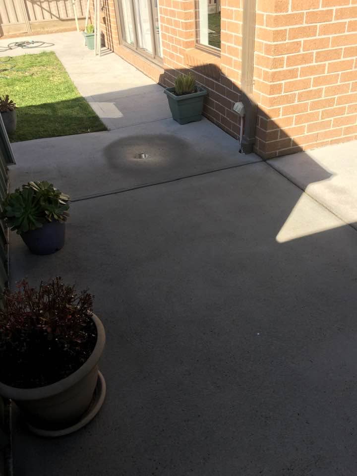 Clean concrete patio area after pressure cleaning, free of dirt and stains