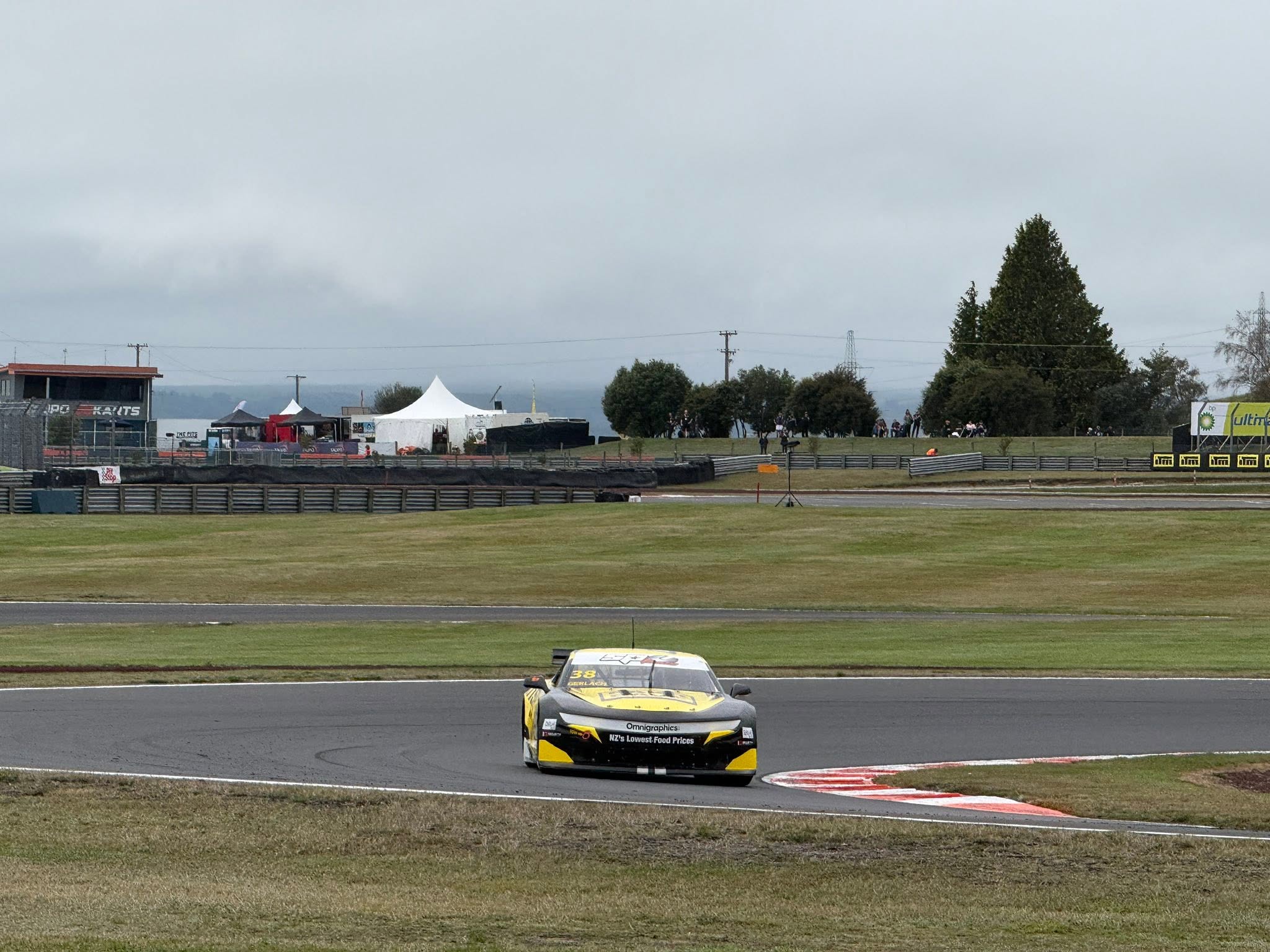 Yellow and black race car approaching a corner