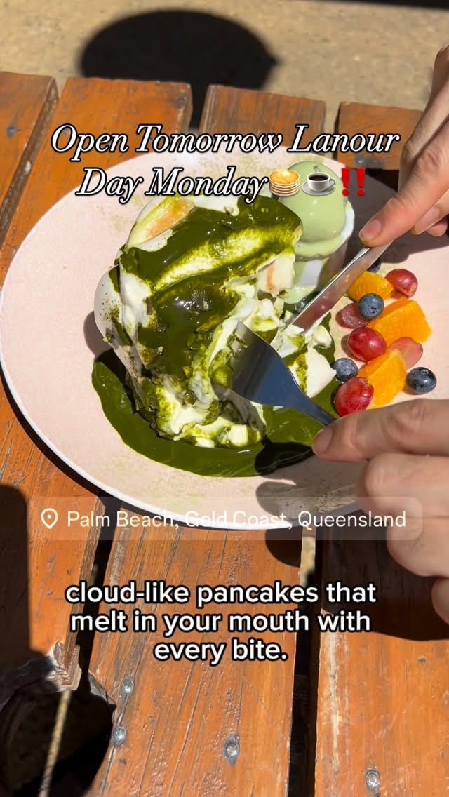 Matcha soufflé pancakes cut open revealing vibrant green matcha sauce, served with fresh fruit on a pink plate