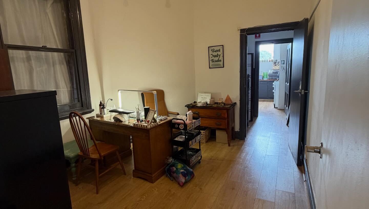 Consultation room with warm timber floors and dark trim at Epping Natural Therapies Centre