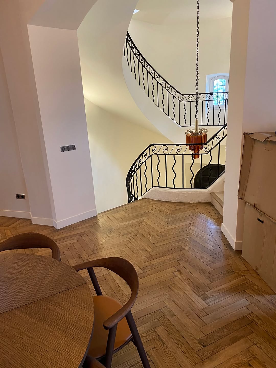 Ornate wrought-iron staircase with herringbone timber floors — the kind of salvageable heritage detail found at Wilson's