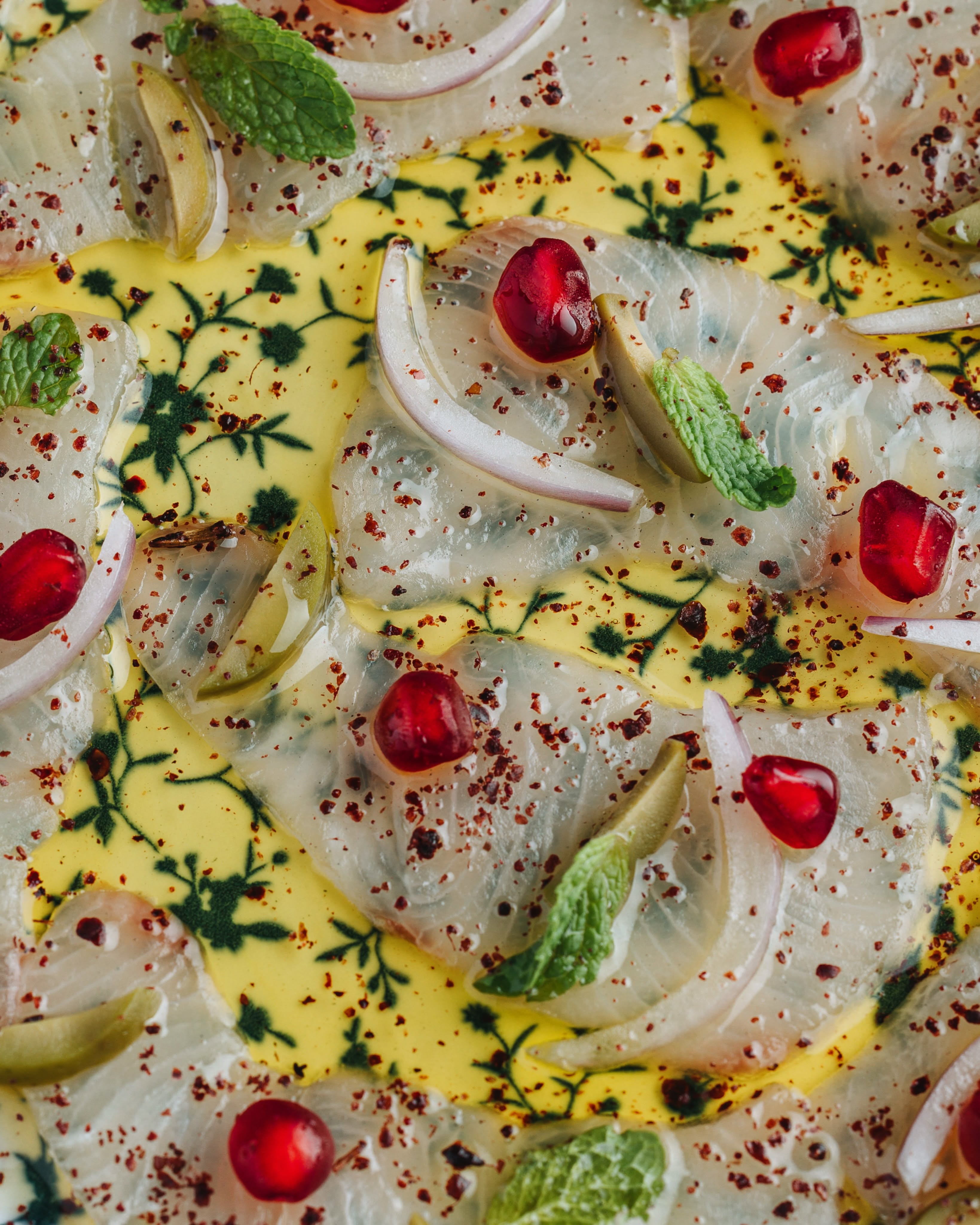 Close-up botanical flat-lay with fennel, pomegranate seeds and fresh herbs — representing Hortus Floral's natural, garden-inspired aesthetic