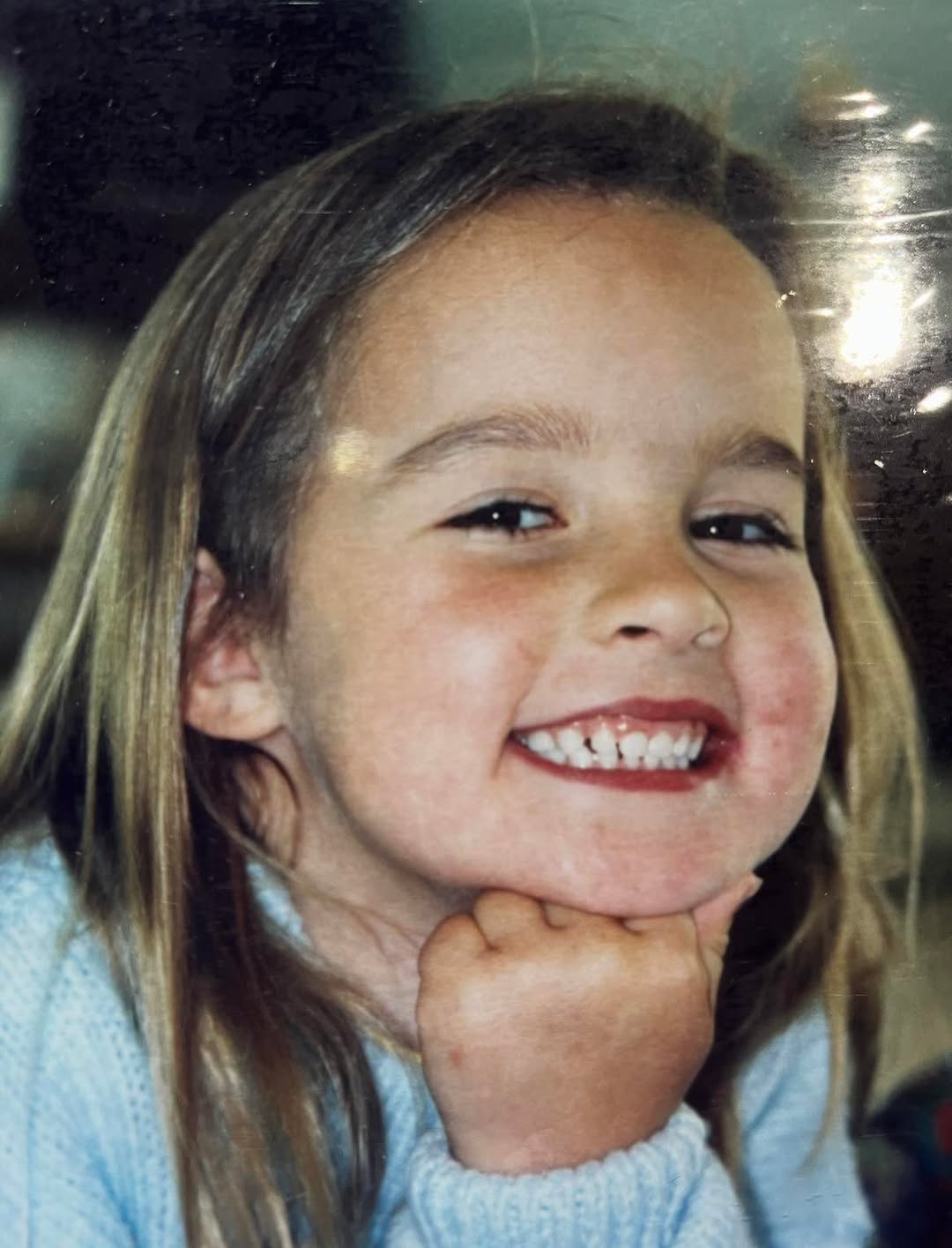 Art supplies including paint brushes and newspaper feature on an outdoor timber table