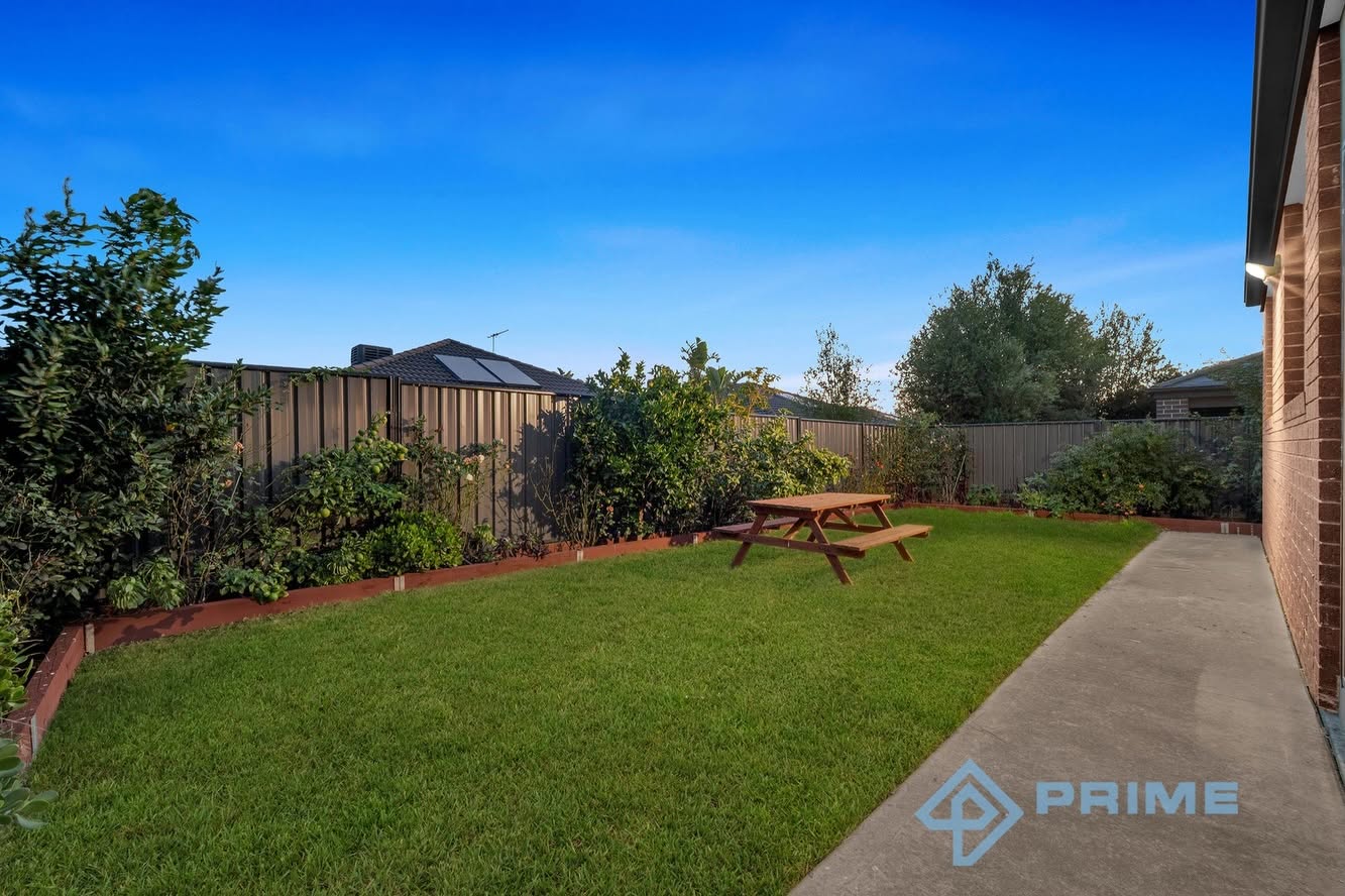 Well-maintained backyard with lawn and garden beds