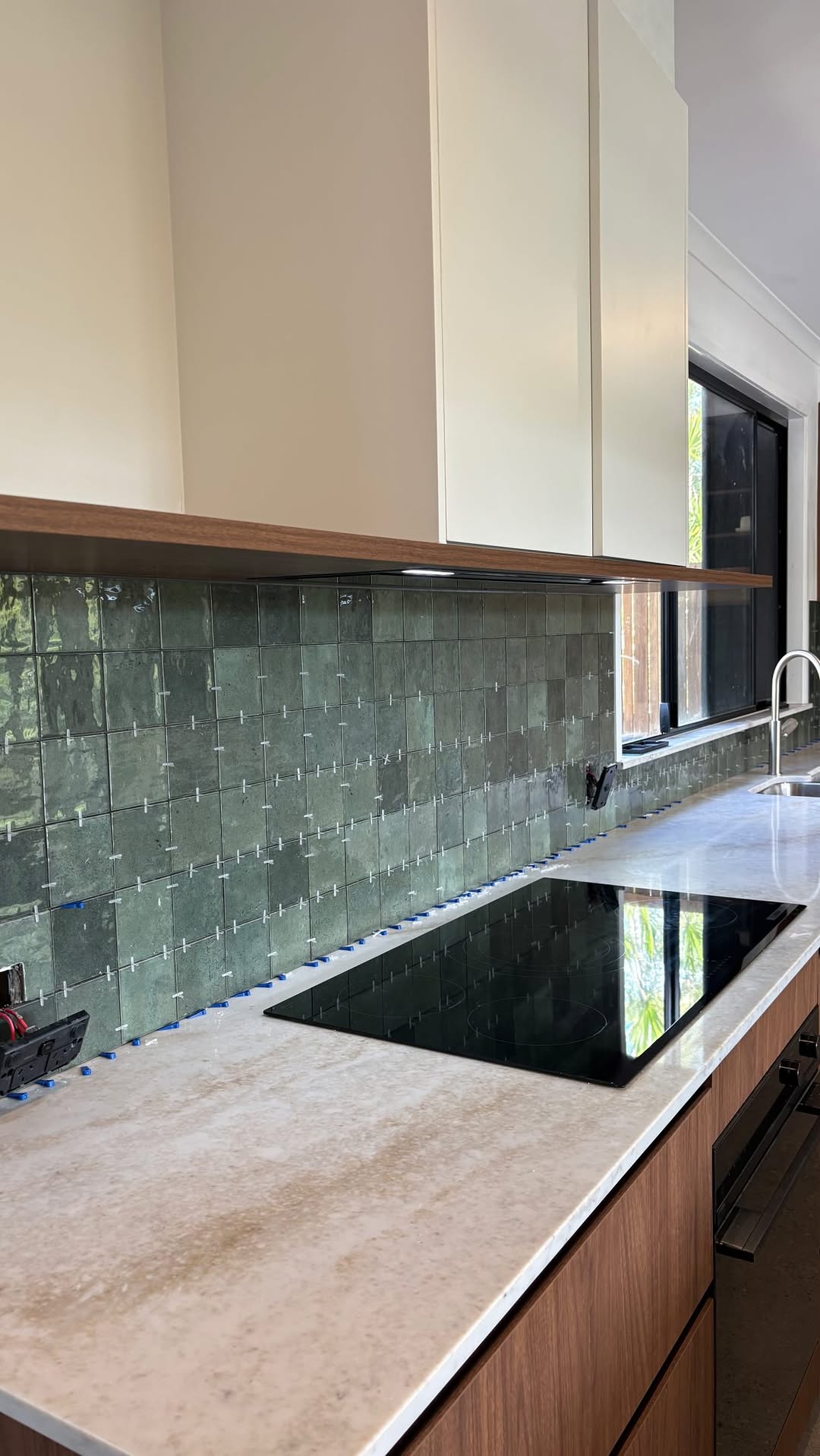 Kitchen splashback tiling in progress — renovation detail