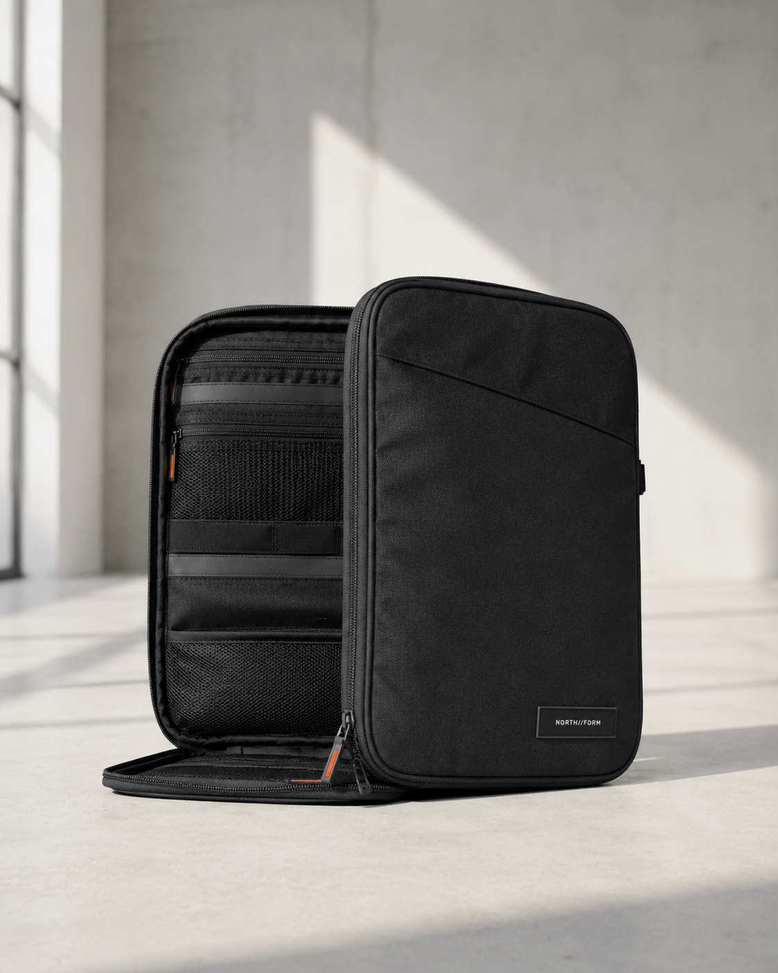 Open tech organizer showing interior organization slots and orange zipper pulls