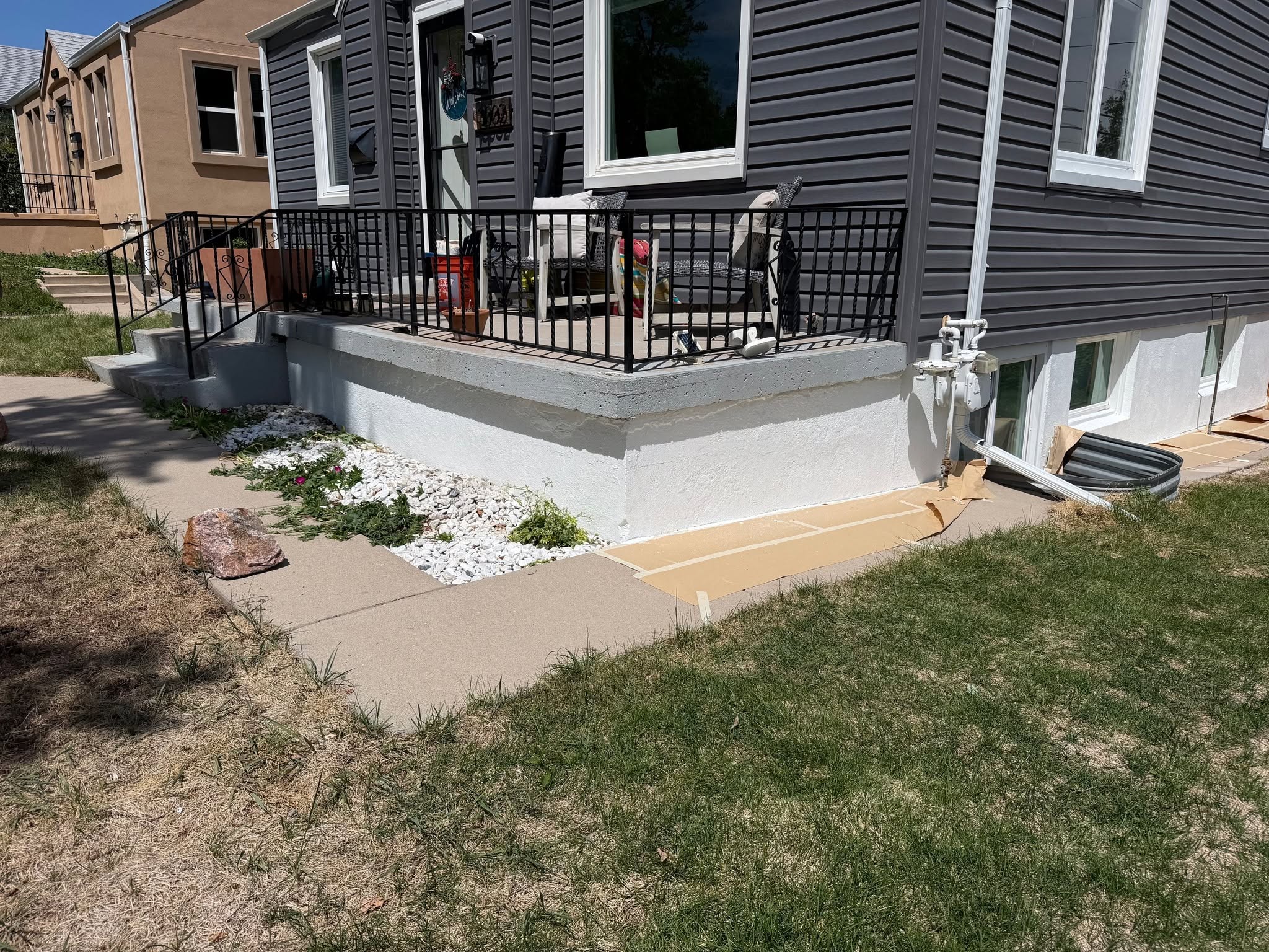 After shot of the same concrete porch foundation with fresh bright white protective masonry coating applied