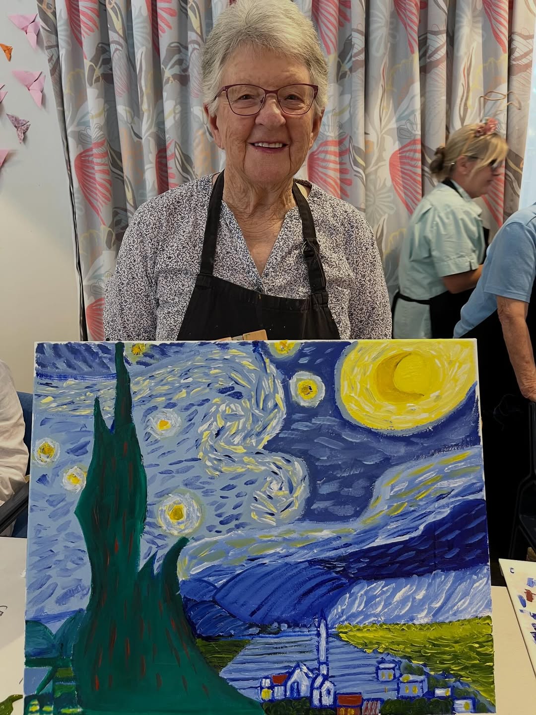 Group of seniors painting together in a bright community room