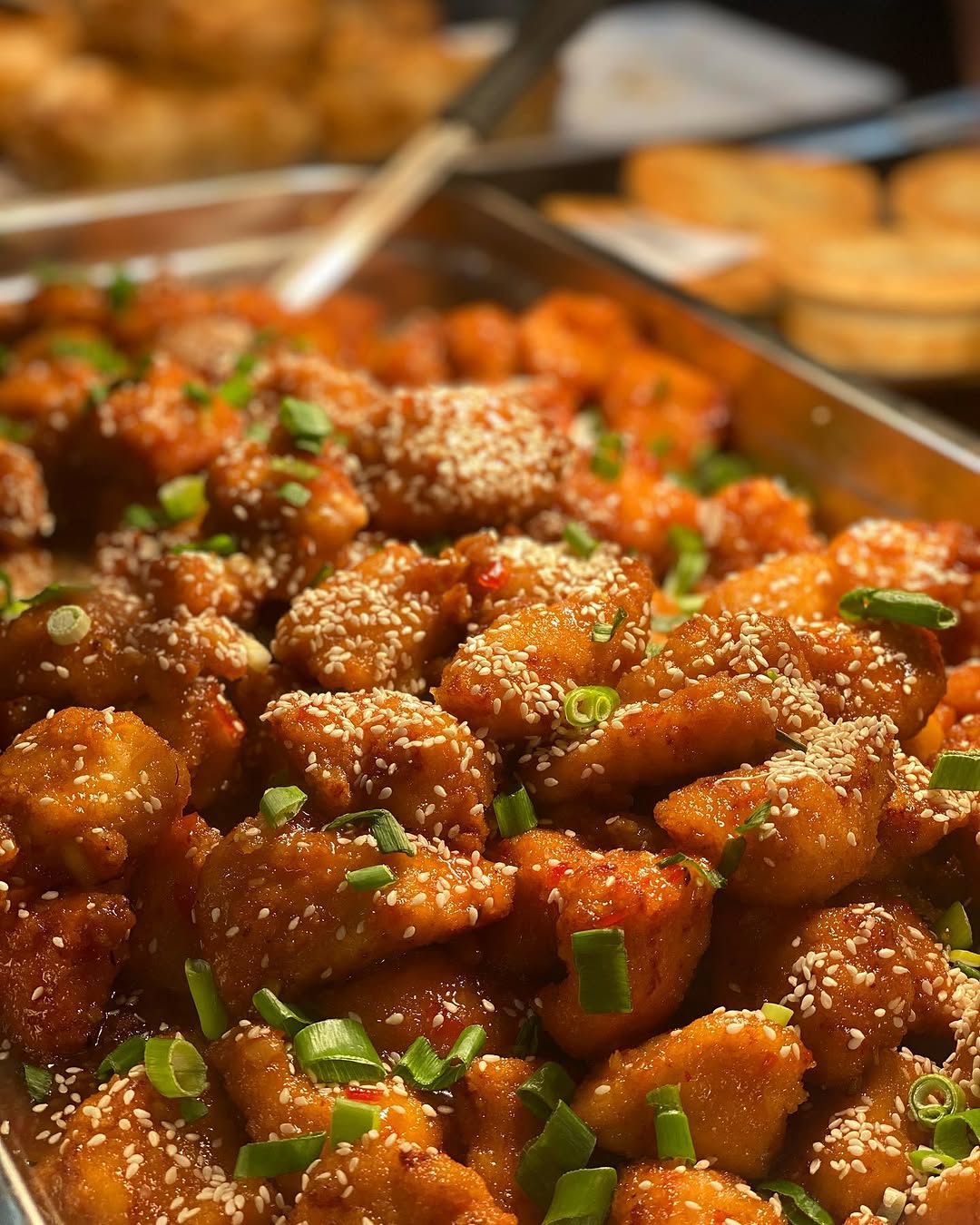 Crispy sesame fried pieces garnished with spring onion
