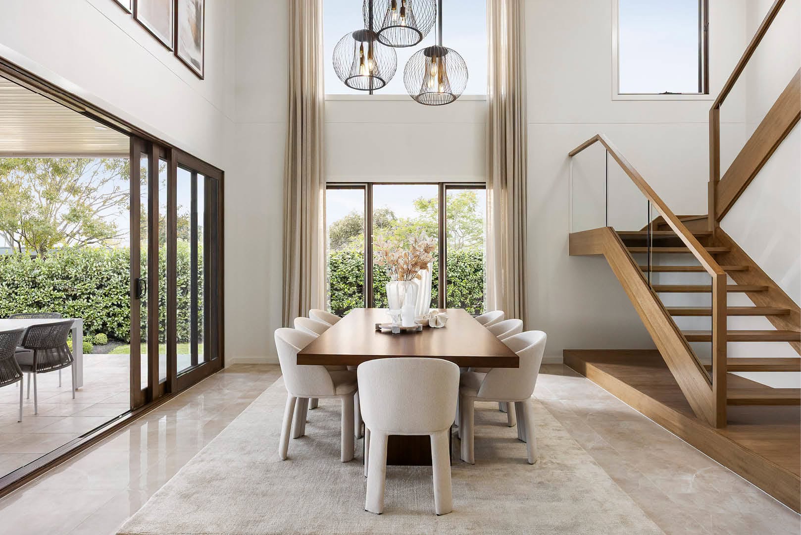 Bright, double-height dining and living space inside a Carlisle Homes display home