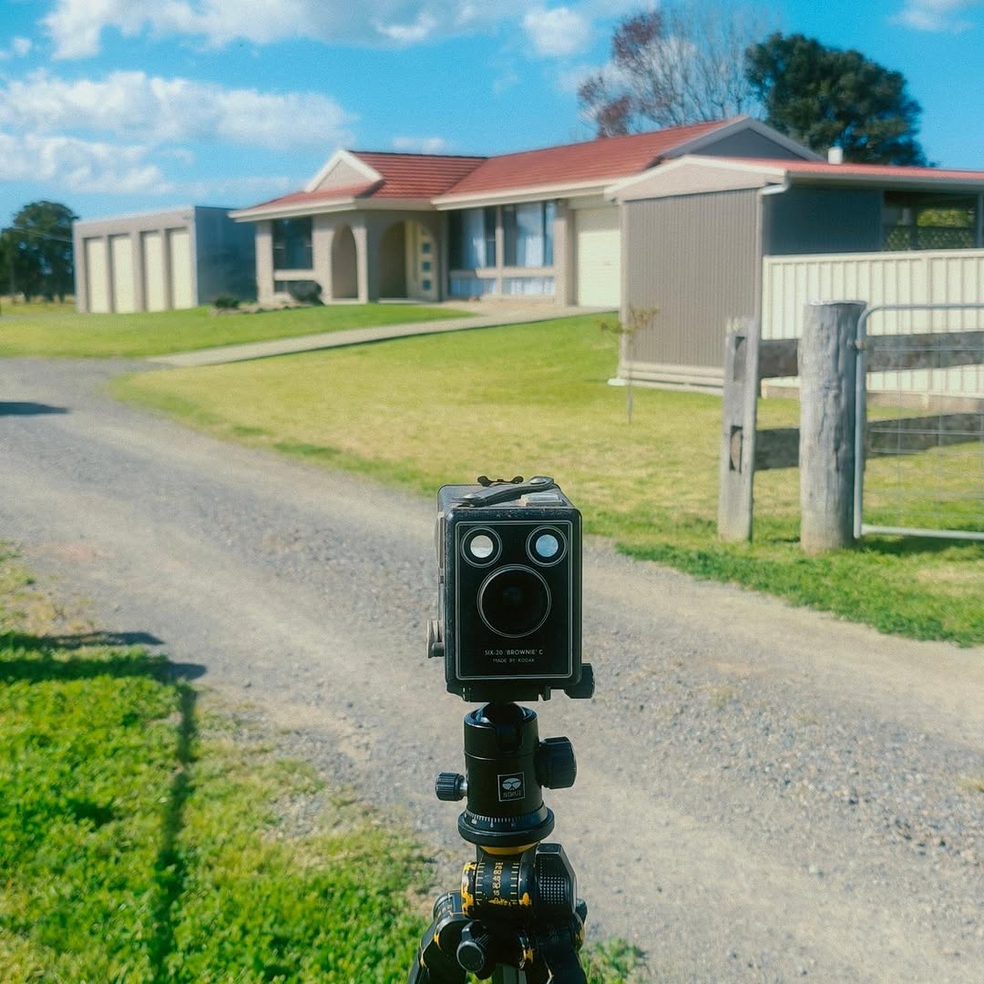 Camera set up on a tripod photographing a residential property for a real estate listing