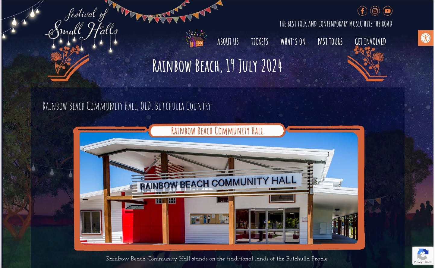 Rainbow Beach Community Hall exterior — modern white building with striking red signage and canopy roof
