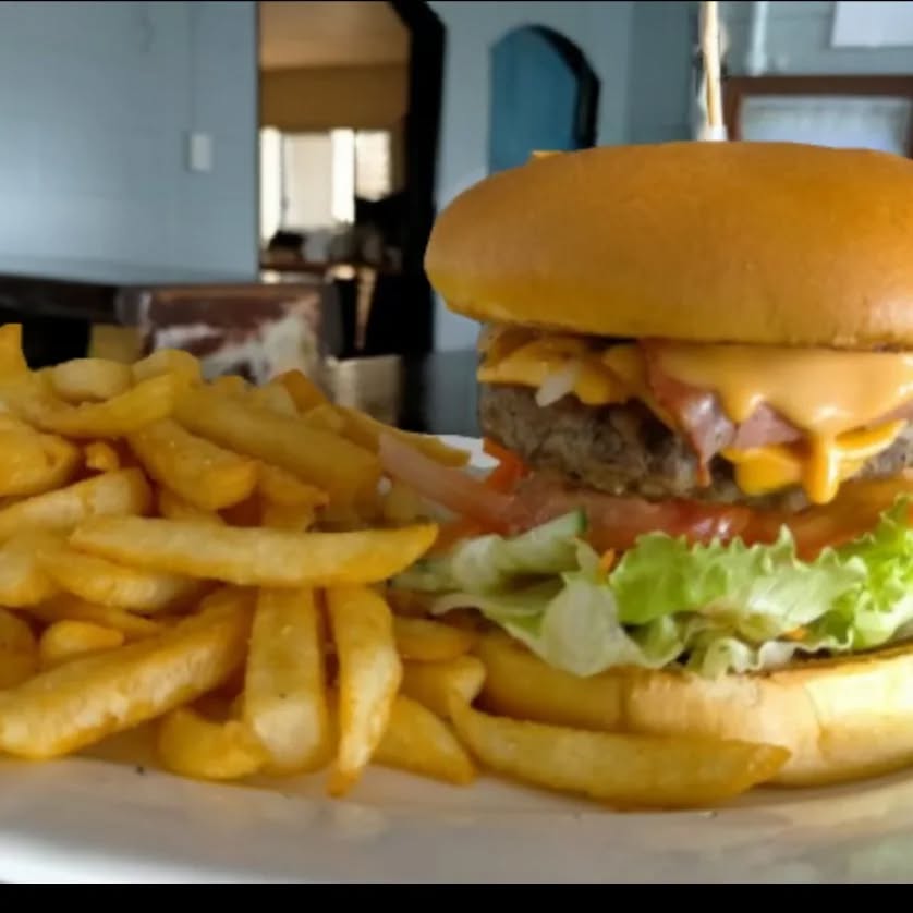 Cheeseburger with chips on a plate at the Yandaran Hotel kitchen