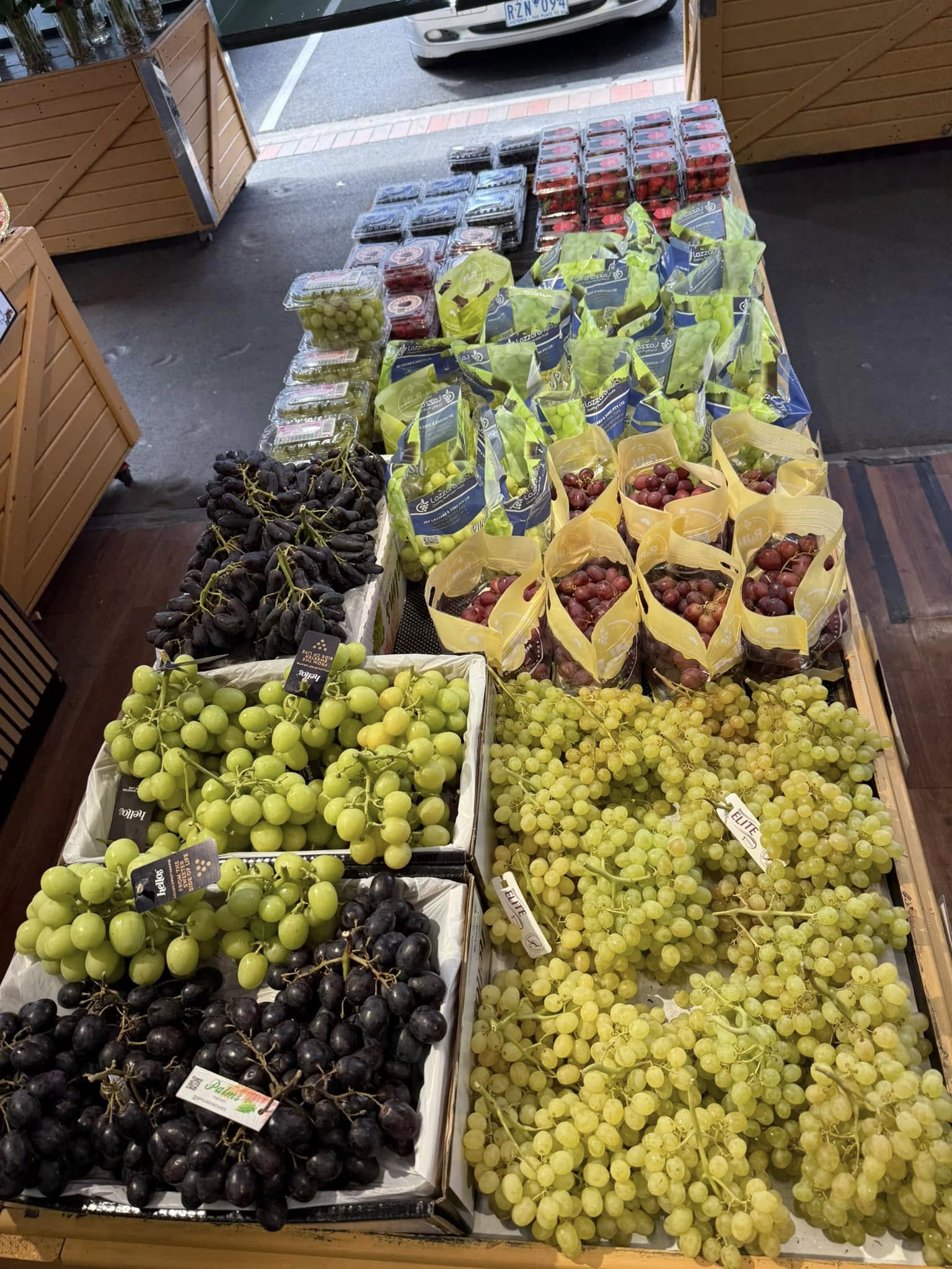 Large display of green and black grapes at Passion For Produce store