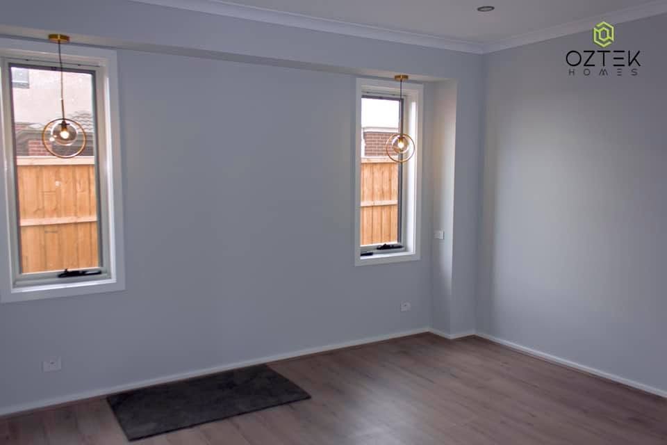 Bedroom with soft grey walls, timber floors, and decorative gold pendant lights