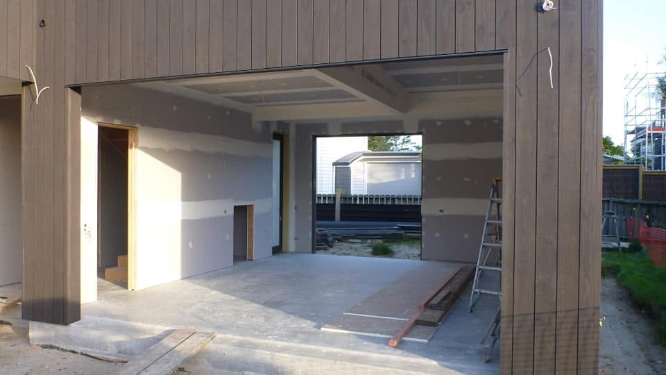 Exterior of a new build with plasterboard visible through open walls during construction