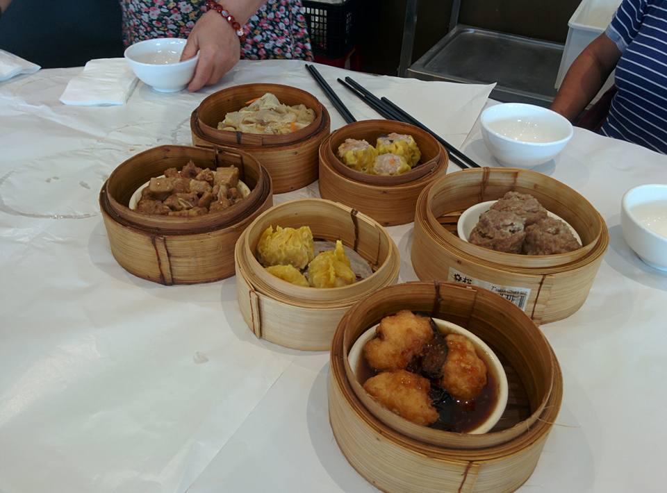 Multiple bamboo steamers of yum cha dim sum dishes on a table at Golden Horse Restaurant