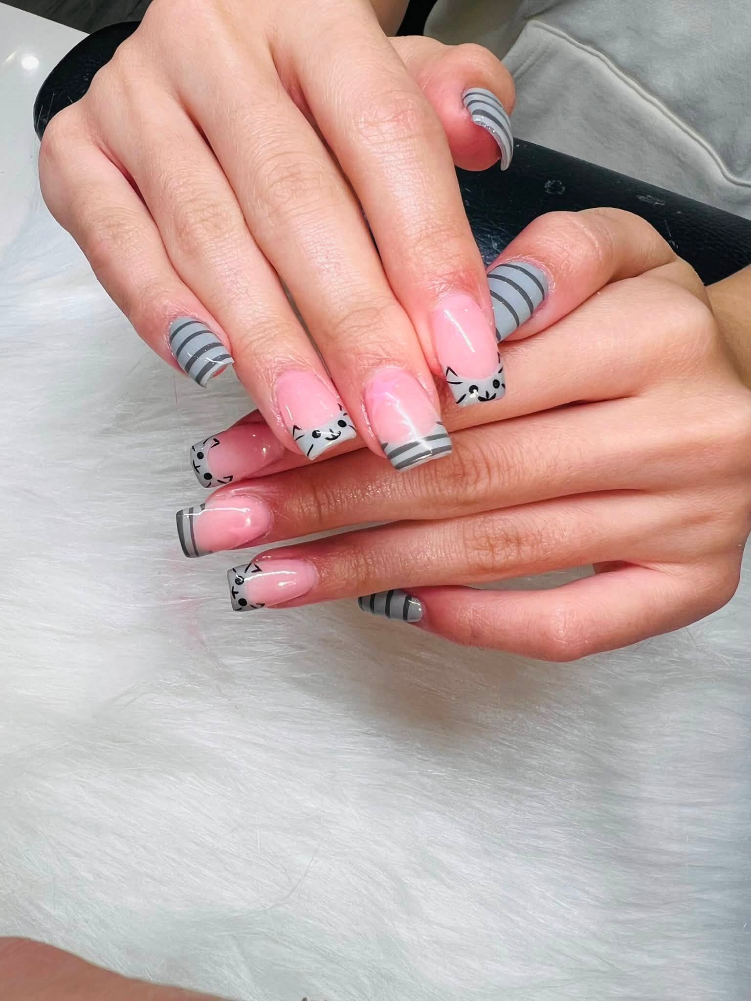 Grey and pink striped nails with cat face design
