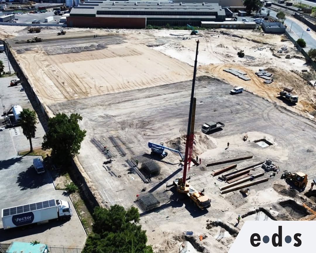 Aerial view of construction site with crane and structural steel foundations