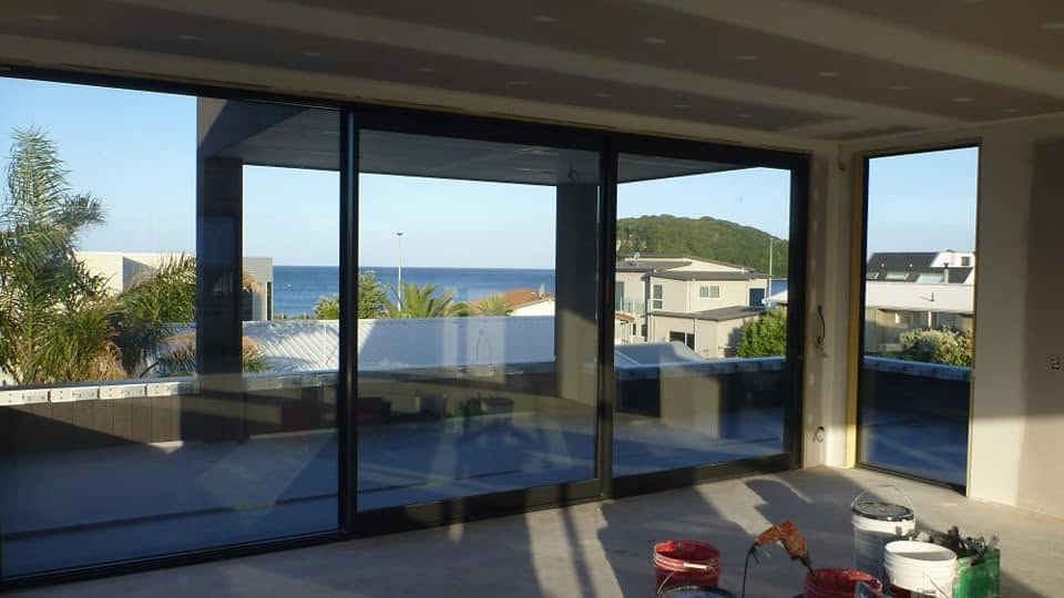 Newly plastered interior with large sliding door windows overlooking coastal views