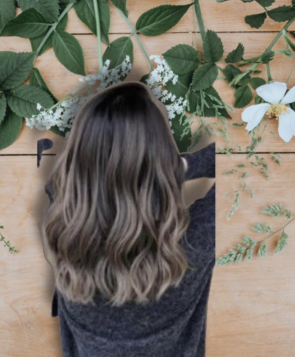 Soft wavy ash-brown hair with lighter ends on a floral backdrop