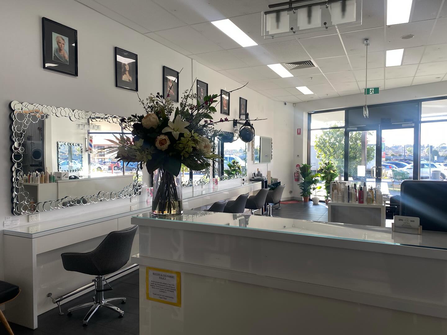 Interior of the Opal Hair salon showing styling chairs, mirrors and a fresh flower arrangement